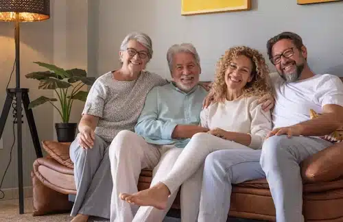 Une famille multi-générationnelle assise ensemble sur un canapé, symbolisant le bonheur familial et la tranquillité.