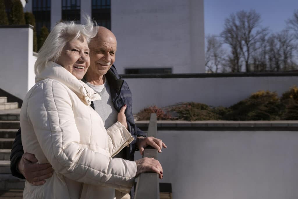 Un couple de seniors profitant d'une journée ensoleillée à l'extérieur, symbolisant la tranquillité de la vie en EHPAD.